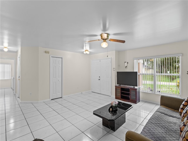 unfurnished living room featuring ceiling fan and light tile patterned floors