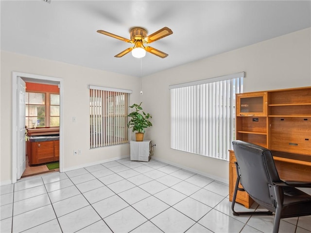 office area featuring light tile patterned floors, baseboards, and a ceiling fan