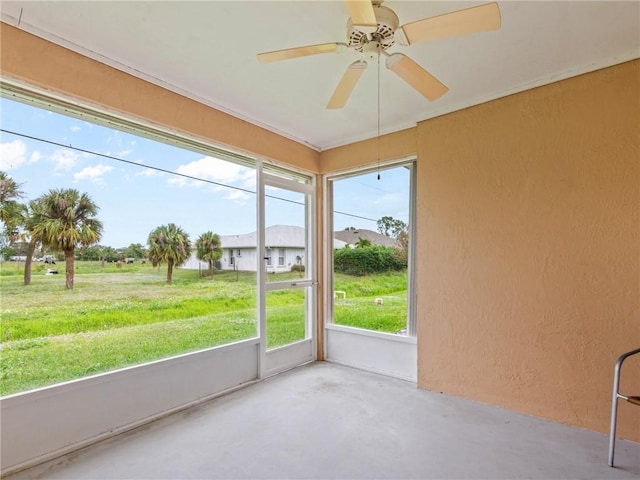 unfurnished sunroom with ceiling fan