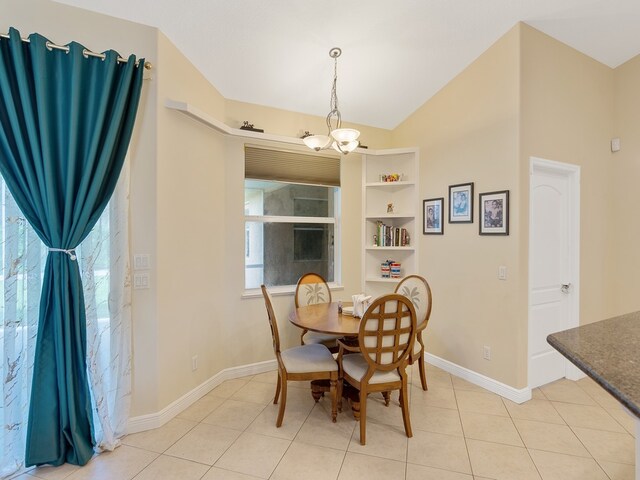 dining room with built in features, a healthy amount of sunlight, light tile patterned floors, and an inviting chandelier