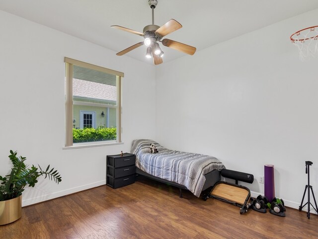 bedroom with dark hardwood / wood-style flooring and ceiling fan