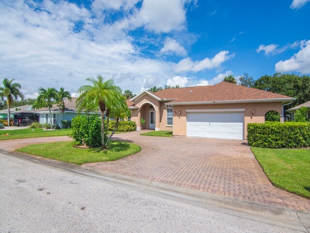 single story home with a garage and a front yard