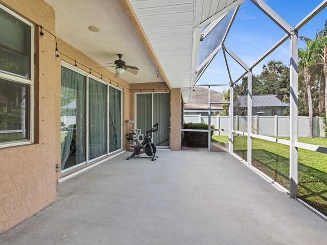 unfurnished sunroom featuring ceiling fan