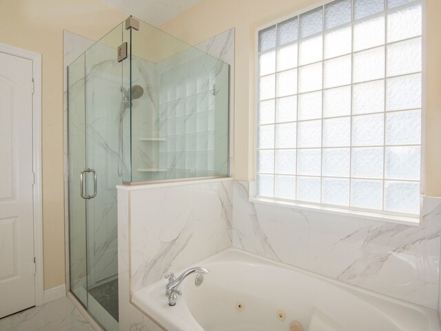 bathroom featuring a healthy amount of sunlight and plus walk in shower