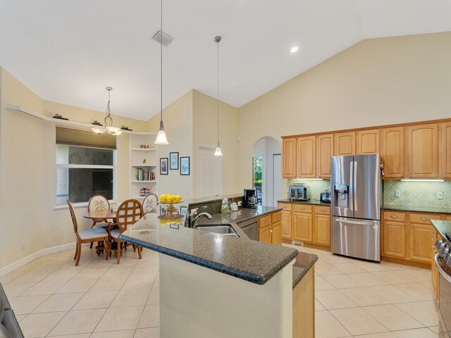 kitchen with appliances with stainless steel finishes, sink, light tile patterned flooring, and hanging light fixtures