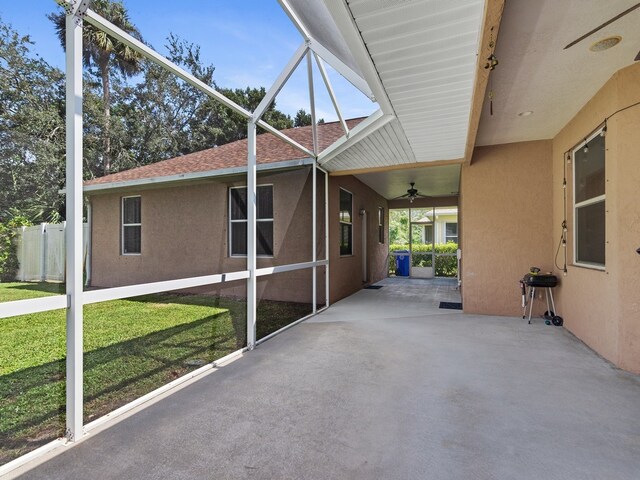 exterior space with a lanai, a lawn, ceiling fan, and a patio area