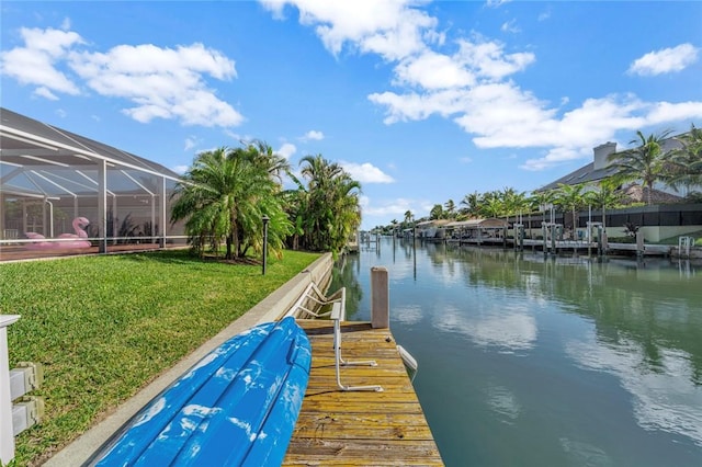 view of dock featuring a lanai, a water view, and a lawn