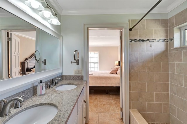 bathroom featuring tile patterned floors, vanity, a tile shower, and crown molding