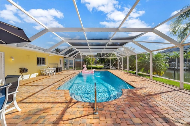 view of swimming pool with a lanai, a patio area, and a water view