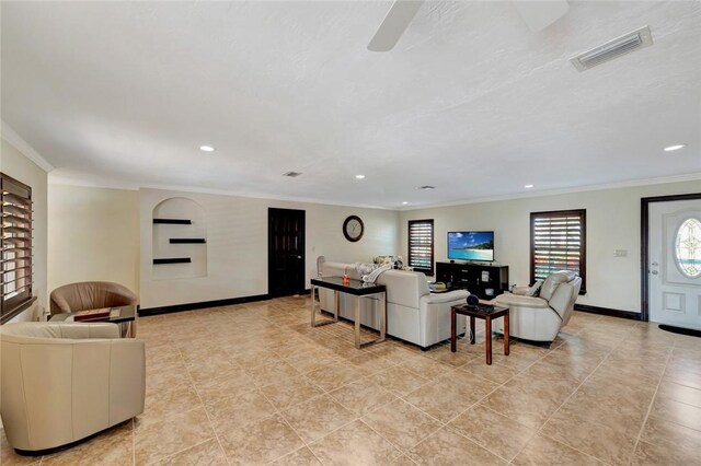 living room with ceiling fan and ornamental molding