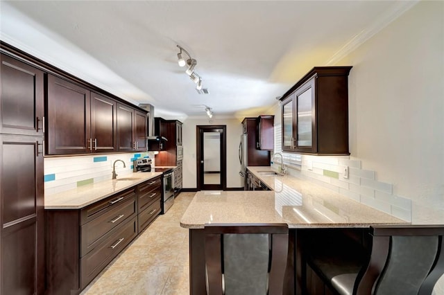 kitchen featuring kitchen peninsula, backsplash, stainless steel range with electric cooktop, and sink