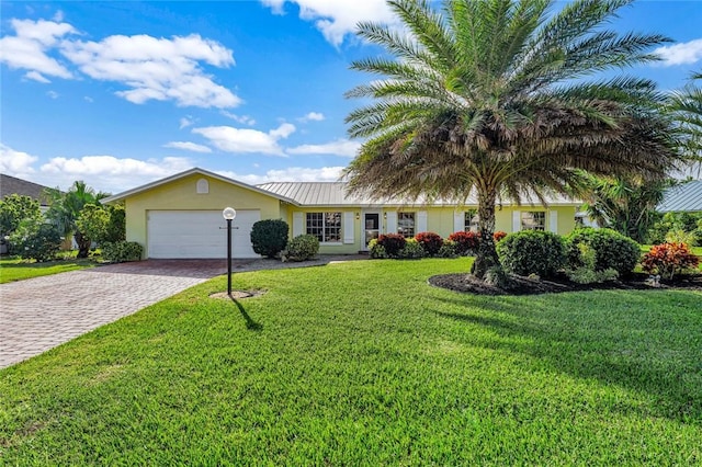 view of front of property featuring a garage and a front lawn