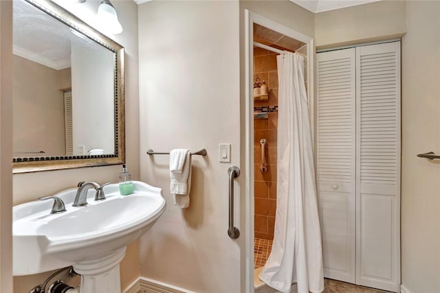 bathroom with curtained shower, crown molding, and sink