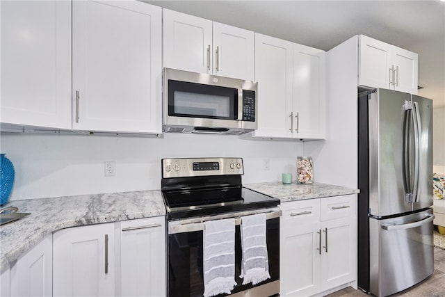 kitchen featuring white cabinetry, appliances with stainless steel finishes, and light stone counters