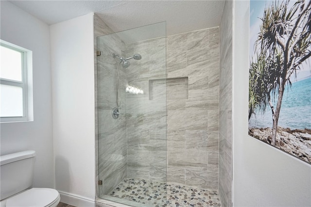 bathroom featuring tiled shower and toilet