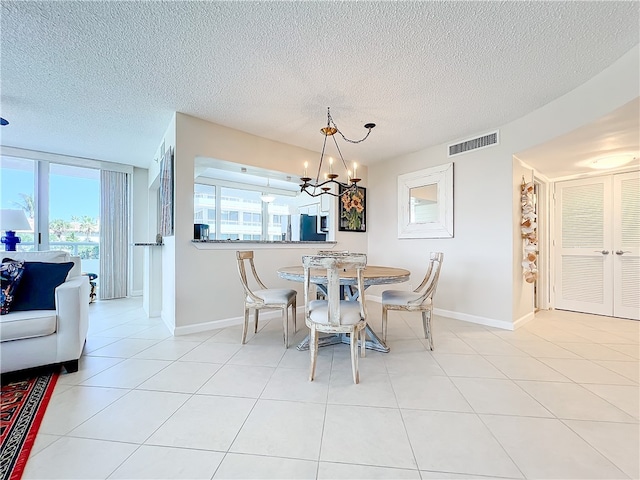 dining area with plenty of natural light, a textured ceiling, and light tile patterned floors