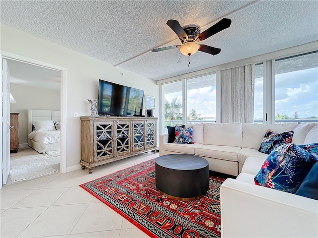 tiled living room with ceiling fan and a textured ceiling