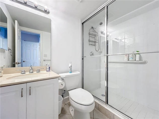 bathroom with toilet, vanity, tile patterned flooring, and a shower with shower door