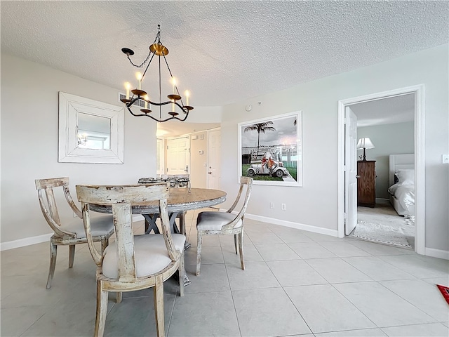 tiled dining room featuring a textured ceiling and an inviting chandelier