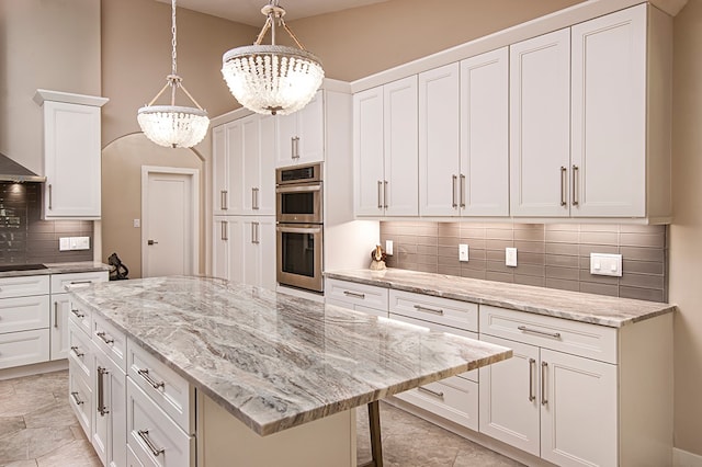 kitchen featuring white cabinets, pendant lighting, double oven, and a notable chandelier