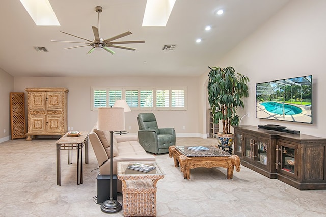 living room featuring a skylight, ceiling fan, and high vaulted ceiling