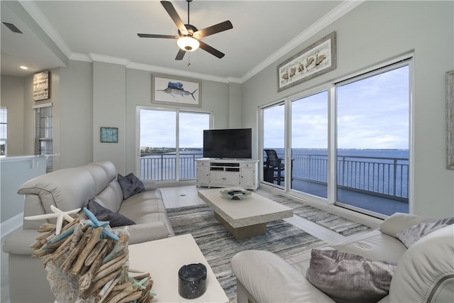 living room featuring a wealth of natural light, visible vents, and crown molding