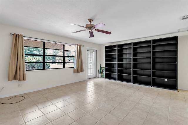 spare room with ceiling fan and light tile patterned flooring