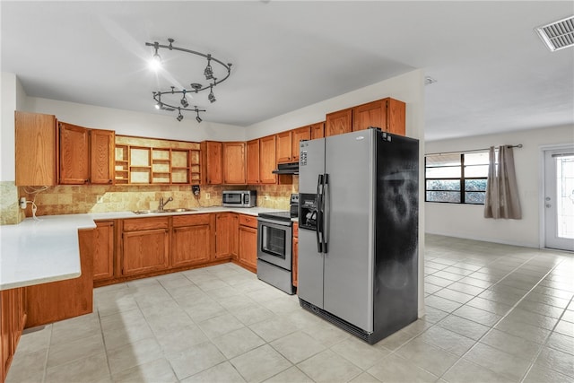 kitchen with light tile patterned flooring, sink, appliances with stainless steel finishes, and tasteful backsplash