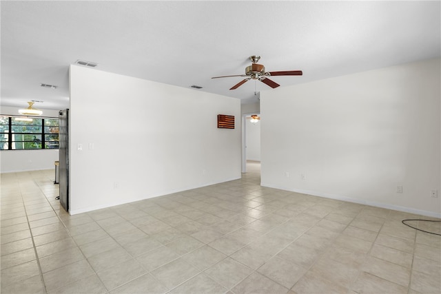 tiled empty room featuring ceiling fan