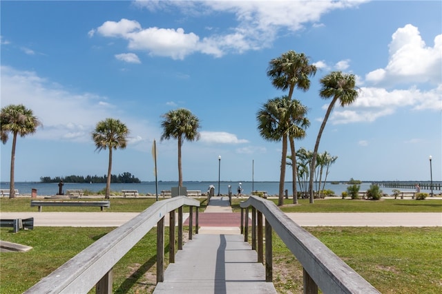 view of property's community featuring a lawn and a water view