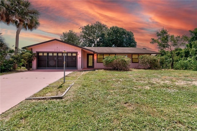 single story home featuring a lawn and a garage