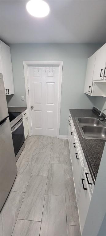 kitchen featuring stainless steel appliances, white cabinetry, and sink