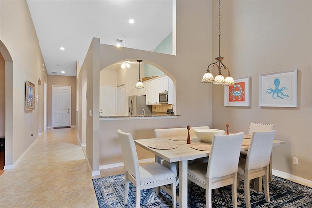 tiled dining space featuring a towering ceiling