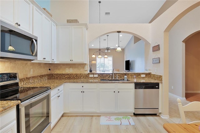 kitchen featuring appliances with stainless steel finishes, stone countertops, sink, and white cabinets