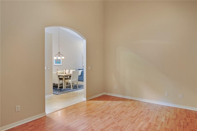 spare room with hardwood / wood-style flooring and a chandelier