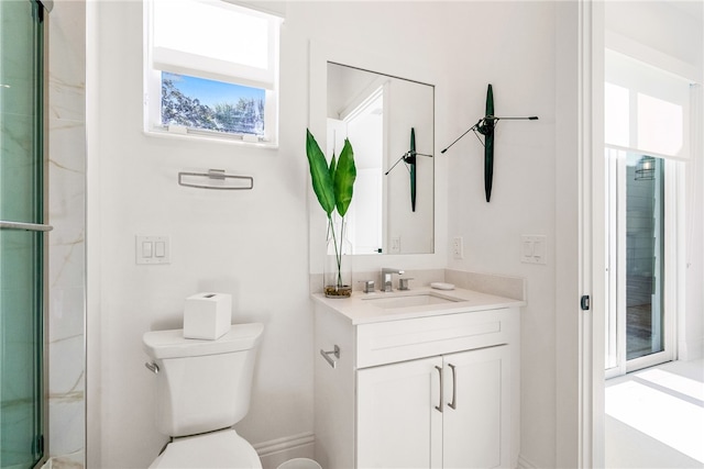 bathroom with vanity, toilet, and a shower with door