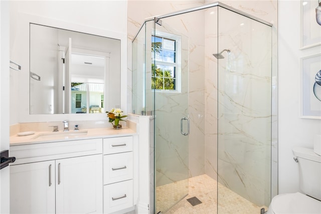 bathroom with toilet, vanity, and a shower with door