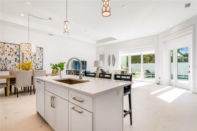 10 Strand Dr, Vero Beach, FL 32963 - kitchen featuring a sink, open floor plan, hanging light fixtures, light countertops, and a kitchen island with sink