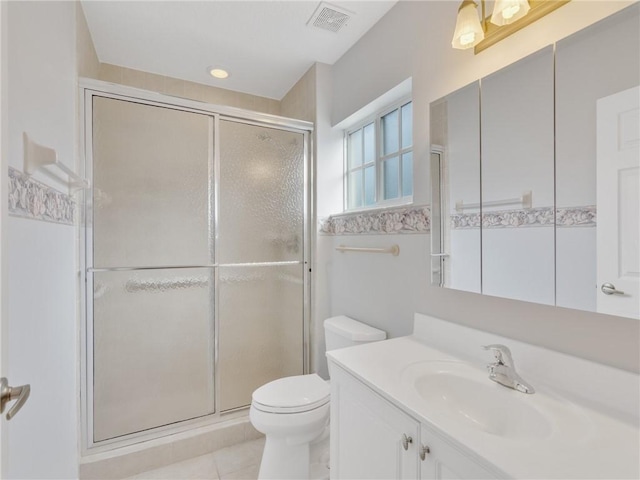 bathroom with tile patterned floors, a shower with door, vanity, and toilet