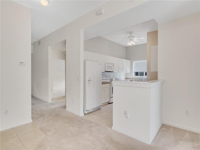 kitchen featuring white appliances, white cabinets, ceiling fan, light colored carpet, and kitchen peninsula