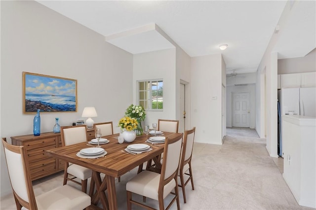 carpeted dining room with ceiling fan