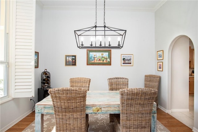 dining room featuring a notable chandelier, hardwood / wood-style flooring, and ornamental molding