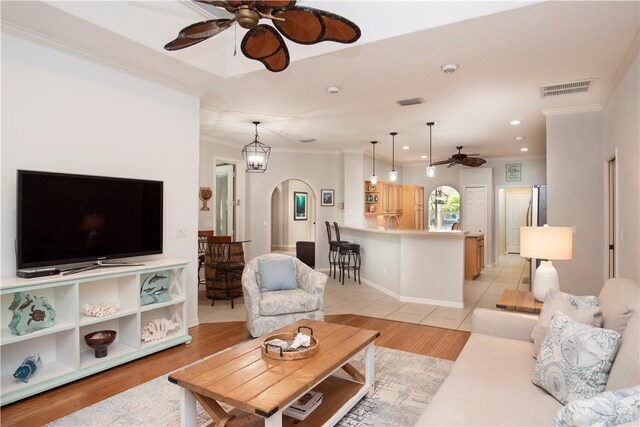 kitchen featuring appliances with stainless steel finishes, pendant lighting, sink, a center island, and crown molding