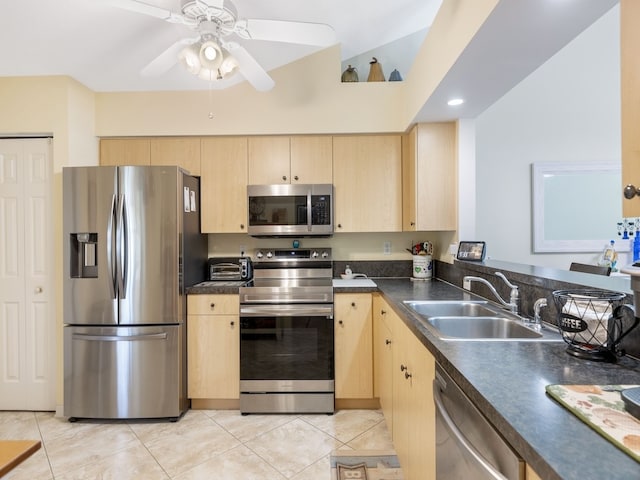 kitchen featuring light brown cabinetry, stainless steel appliances, sink, lofted ceiling, and light tile patterned flooring