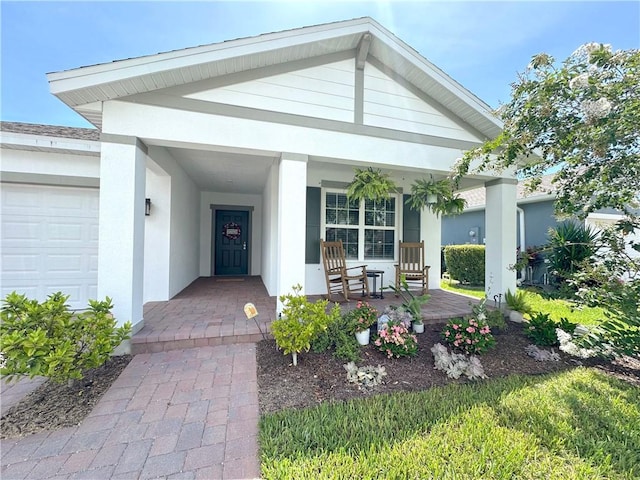 4173 Keeson Cir, Vero Beach, FL 32967 - doorway to property with a porch, stucco siding, and an attached garage