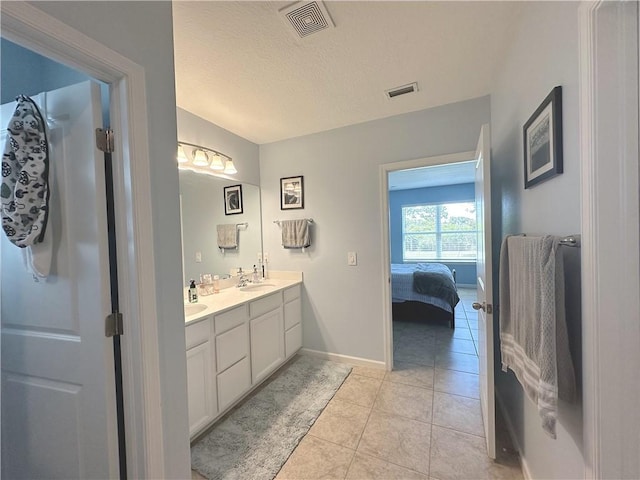 4173 Keeson Cir, Vero Beach, FL 32967 - ensuite bathroom featuring double vanity, tile patterned floors, and a textured ceiling