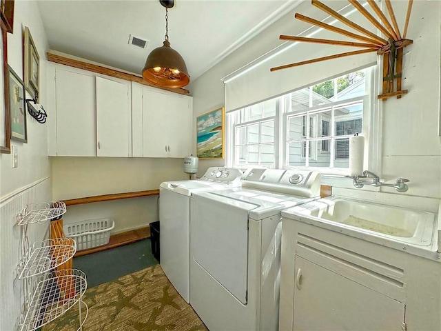 clothes washing area featuring cabinets, washer and dryer, and sink