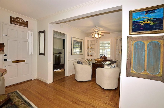 dining space with hardwood / wood-style flooring, ornamental molding, and ceiling fan