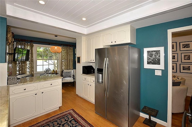 kitchen with light hardwood / wood-style flooring, white cabinetry, hanging light fixtures, stainless steel refrigerator with ice dispenser, and light stone countertops