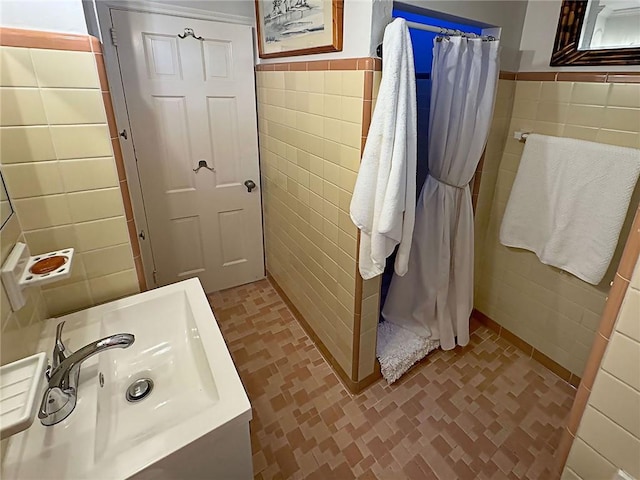 bathroom with tile walls, sink, and tile patterned flooring